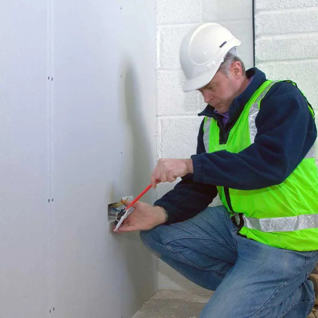 Electrician installing socket on a plasterboard wall in Glasgow