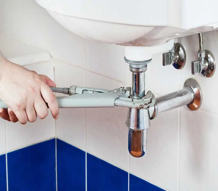 Man carrying out plumbing maintenance Glasgow